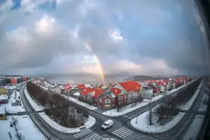 Burzowe chmury nad polskim miastem zimą, śnieg i dramatyczne niebo nad dachami kamienic